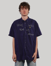 Navy short-sleeve shirt, back view showing small lower patch
