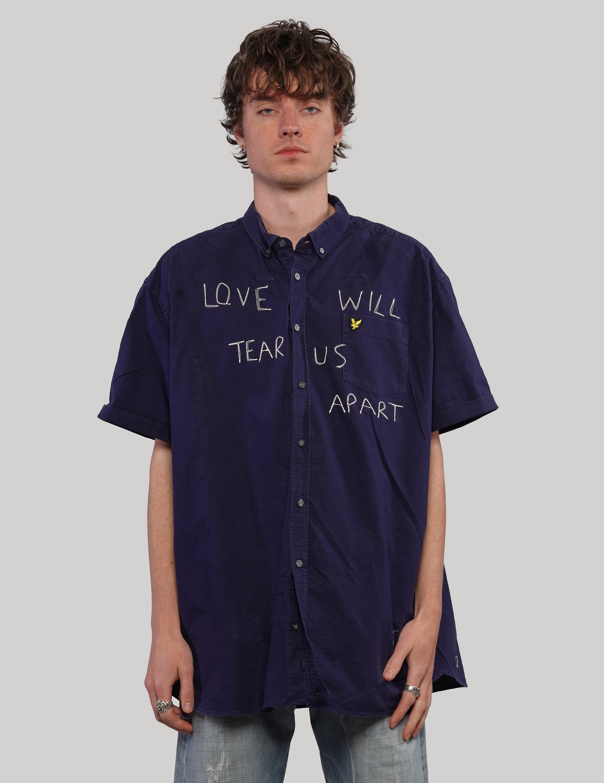 Navy short-sleeve shirt, back view showing small lower patch