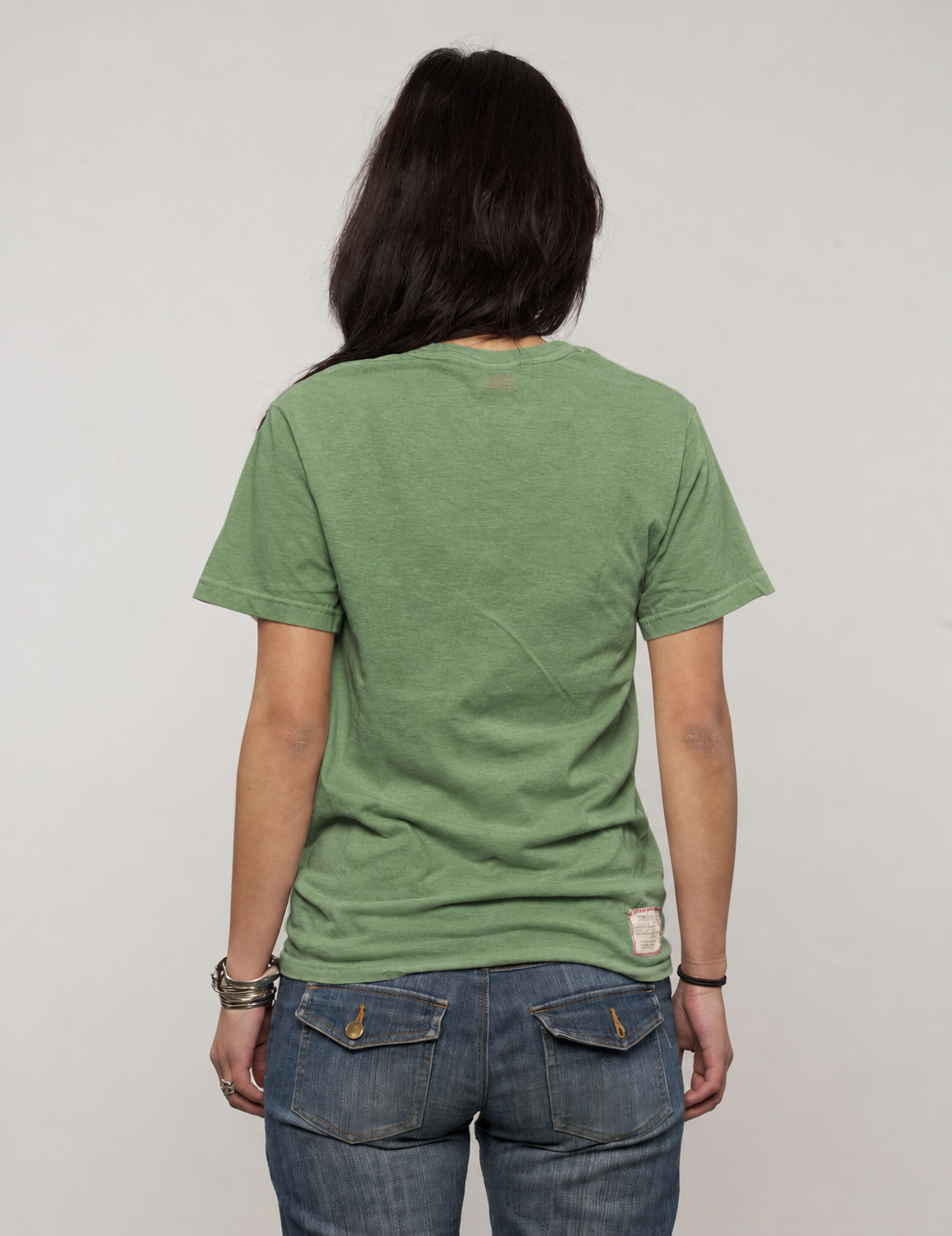 Woman wearing a green Crossed Pistols tee, side view