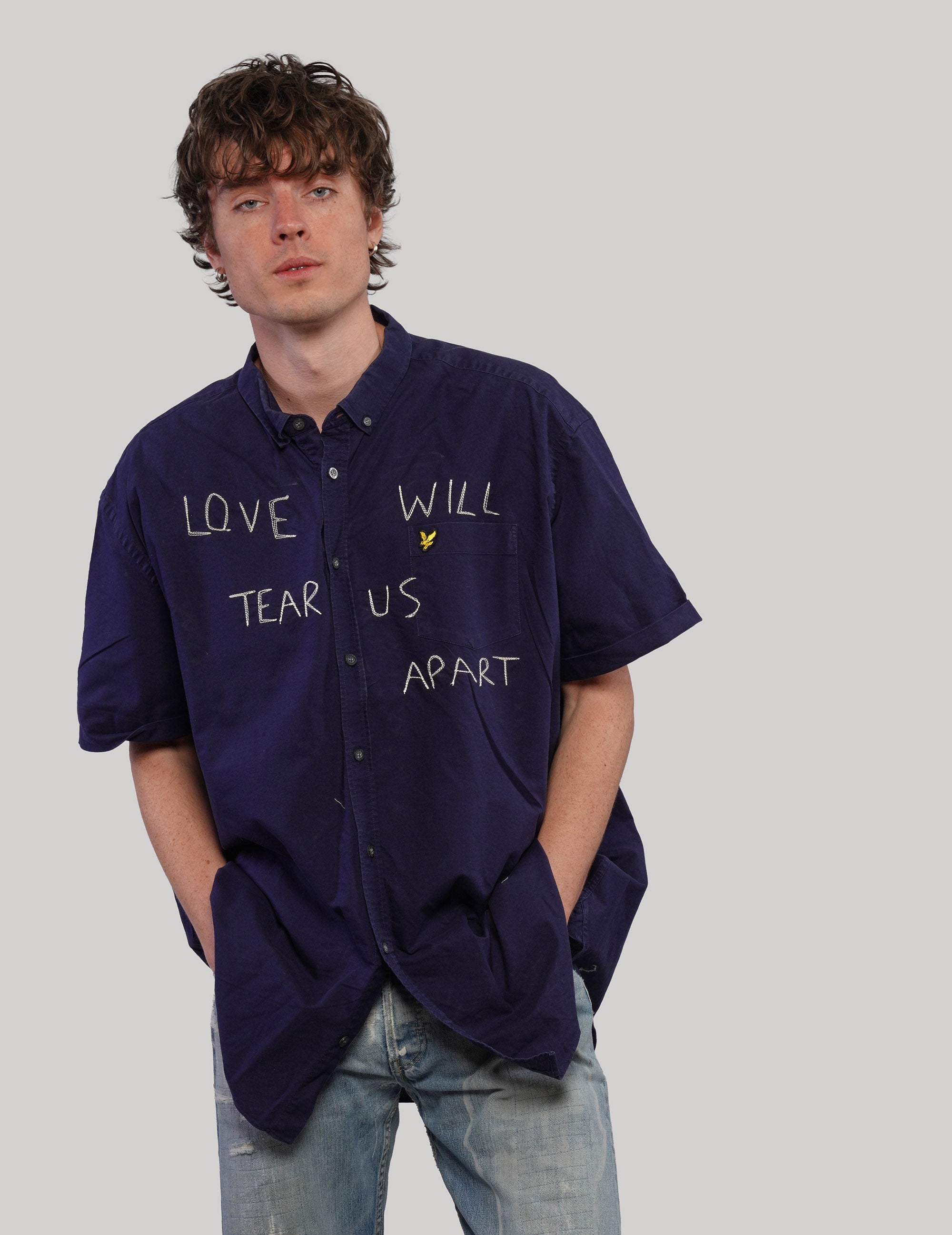 Navy short-sleeve Love Will Tear Us Apart shirt, side view