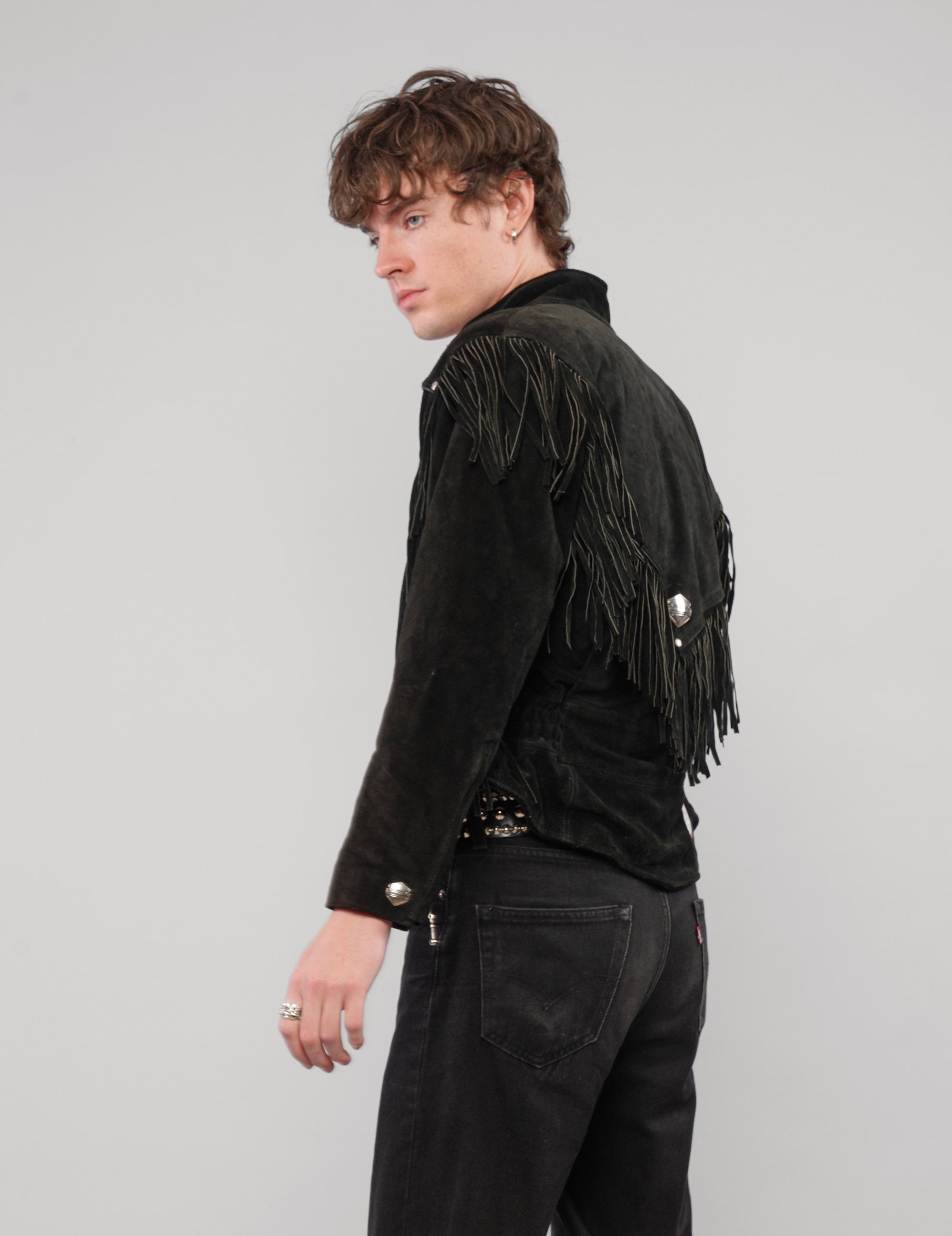 Back three-quarter view of the black jacket with fringe in motion.