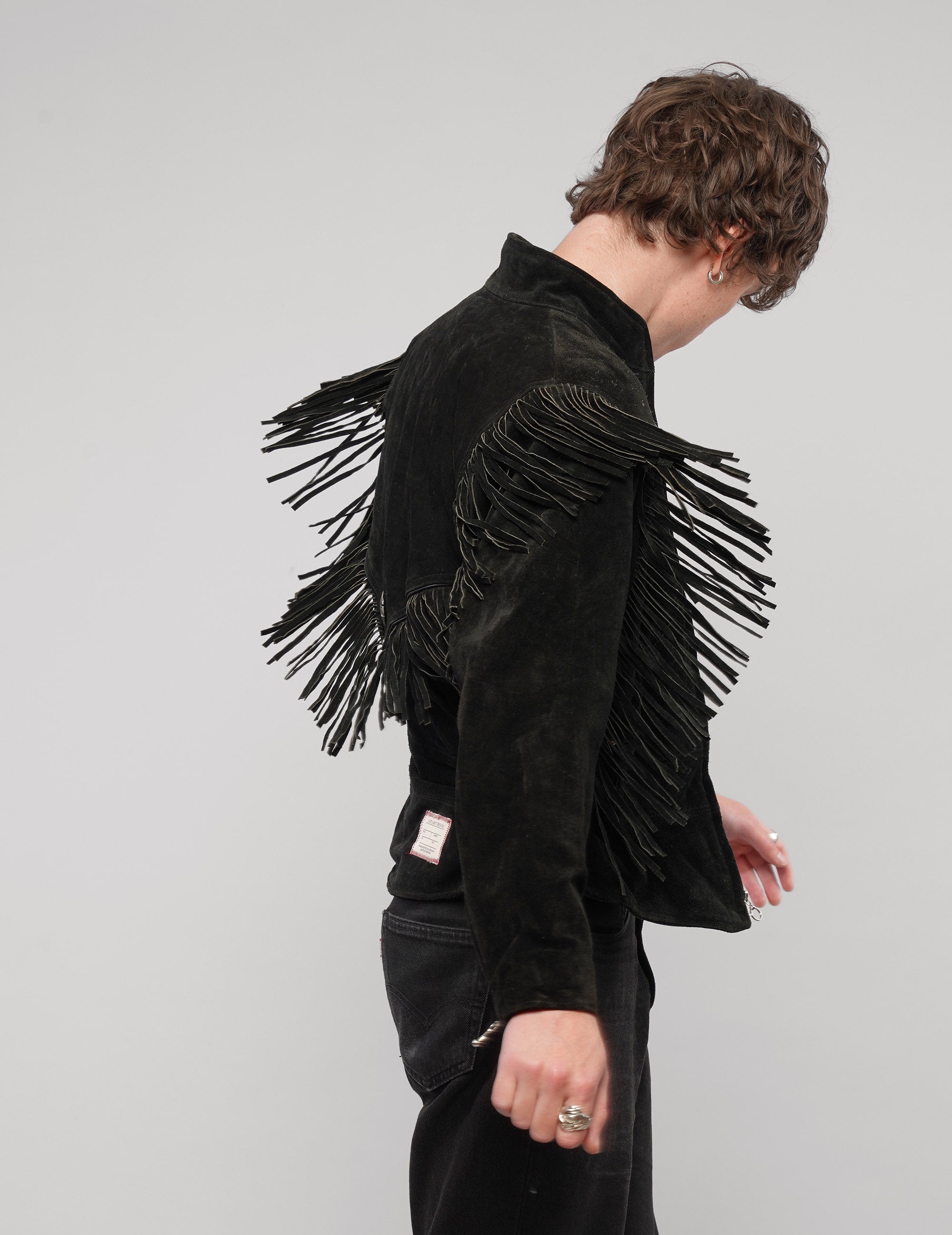Front view of the black jacket showing the studded yoke and fringe.