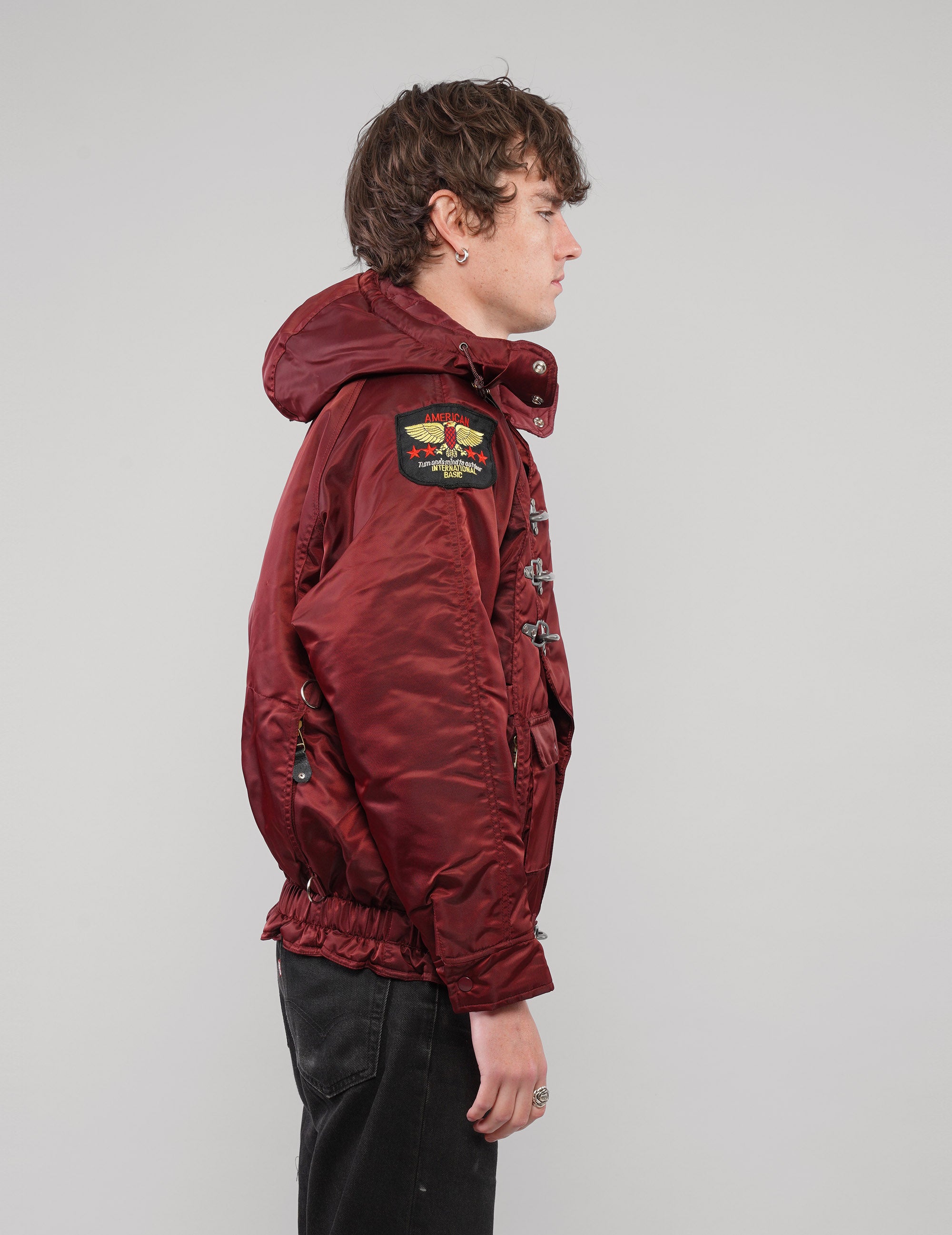 Right side view of a burgundy hooded clasp-front jacket.