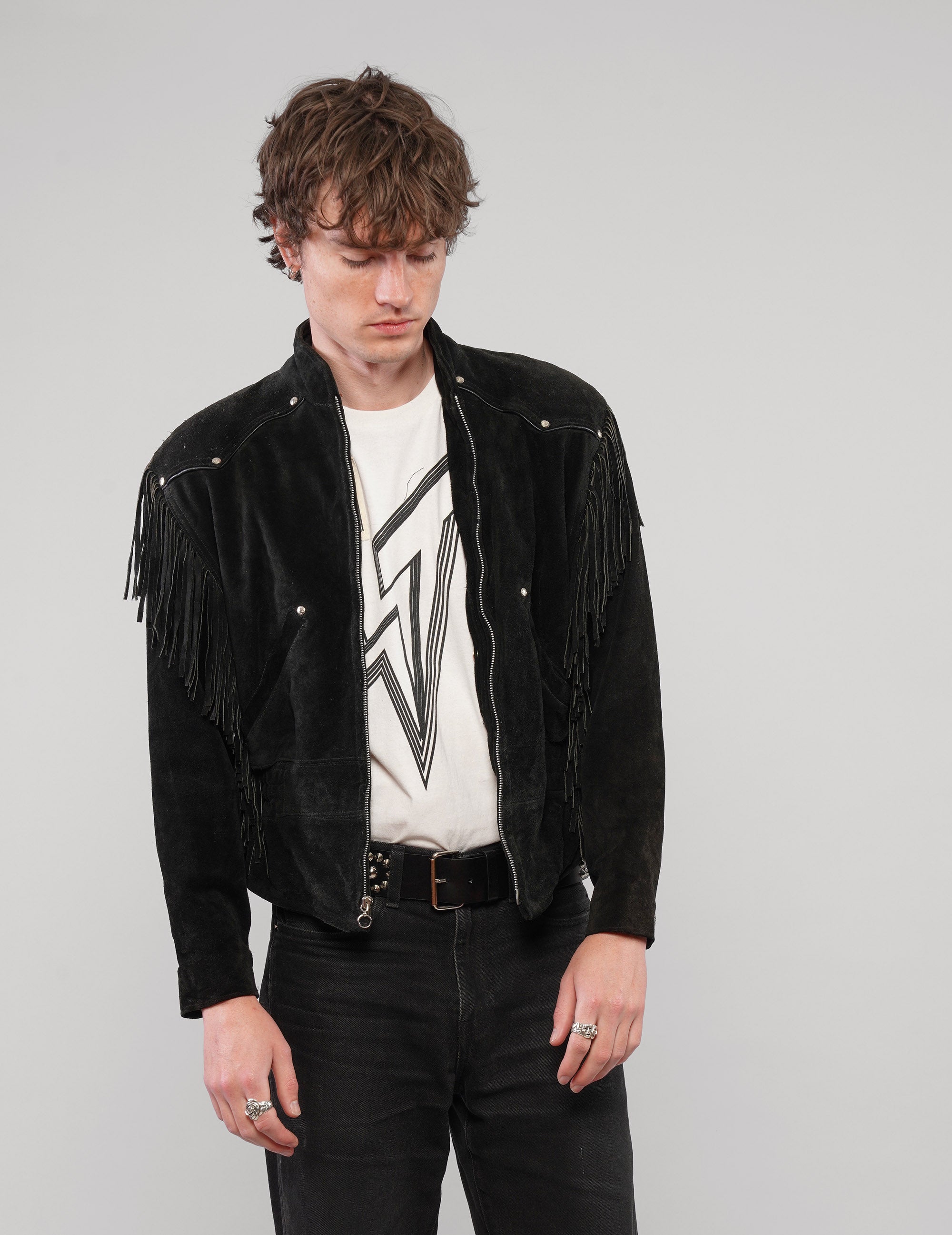 Front view of the black studded fringed zip jacket worn open.