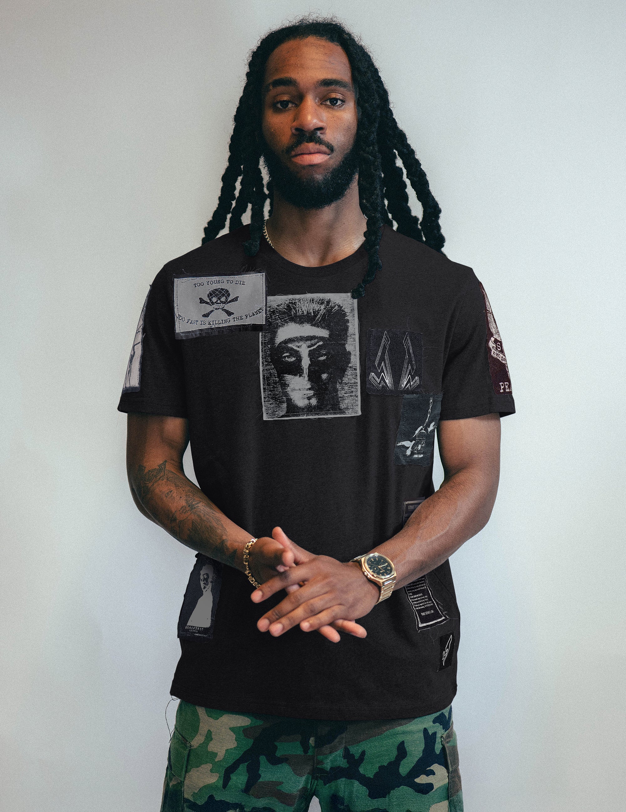 Man wearing a black t-shirt with graphic designs against a plain background