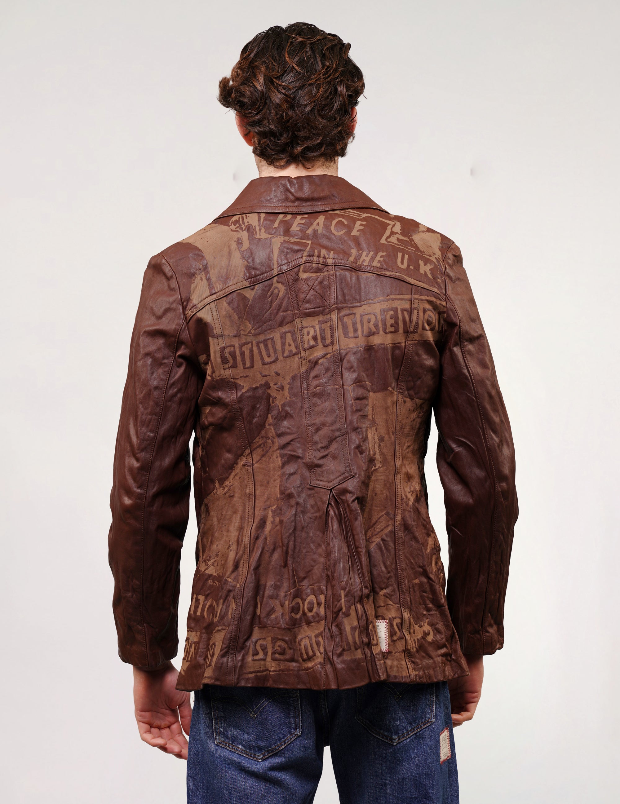 Back of brown leather jacket with laser printed graphic across the shoulders