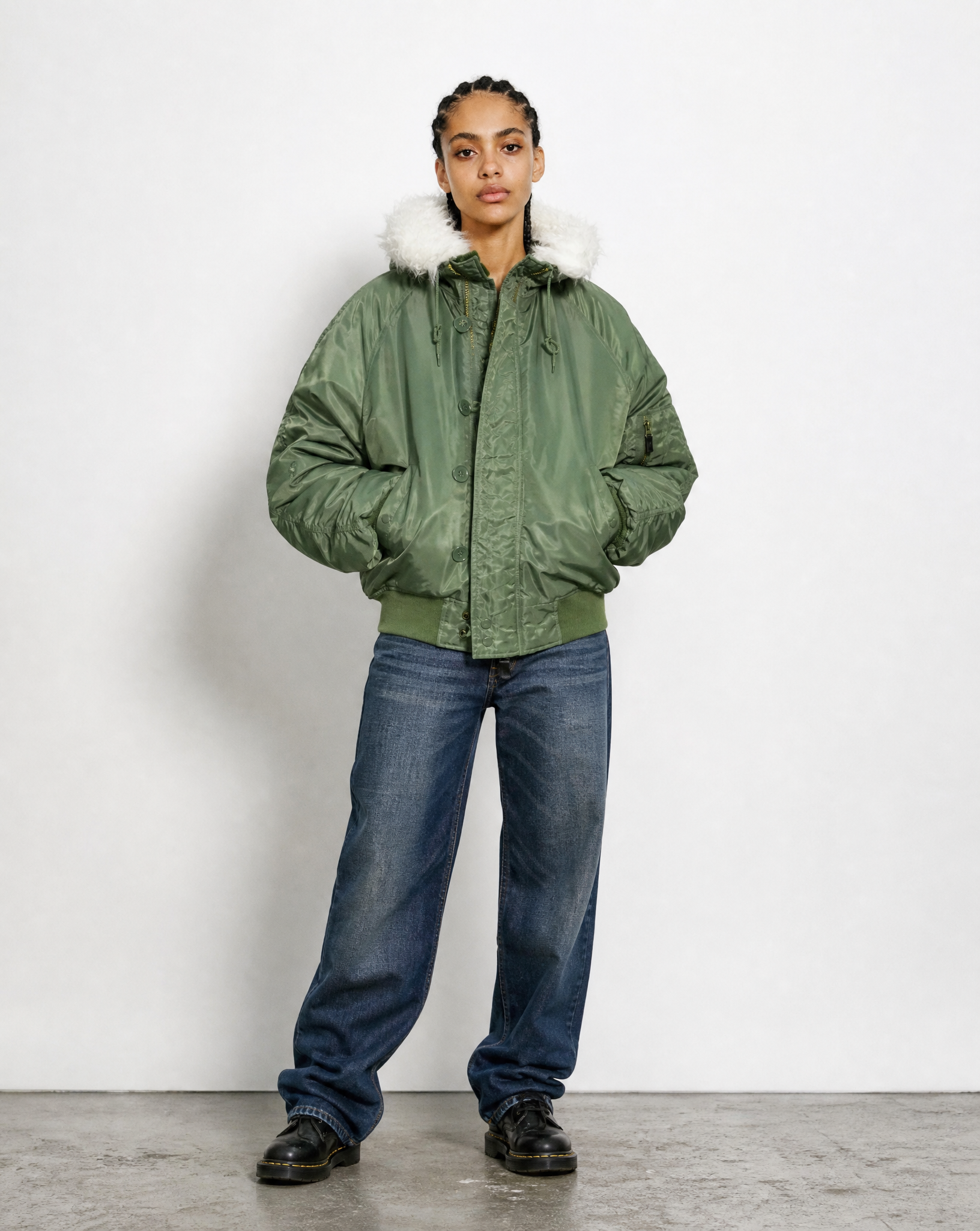 Green N-2B flying jacket worn zipped, showing the fur-trimmed hood and storm flap