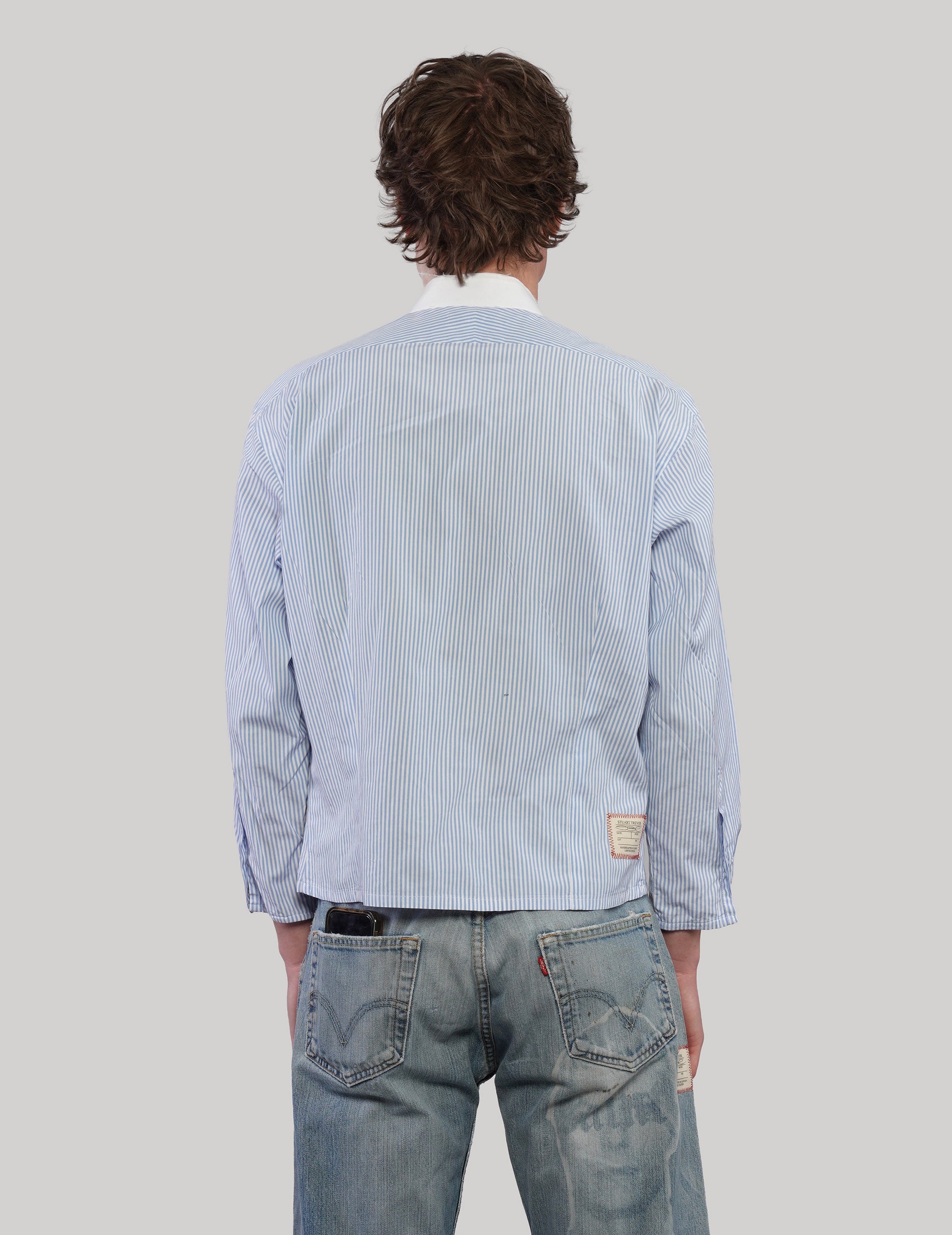 Back view of an upcycled Ralph Lauren light blue pinstripe cropped shirt with long sleeves and a straight hem.