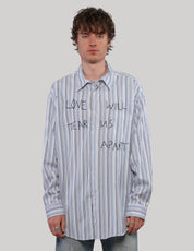 Model wearing a blue multi-stripe Love Will cotton shirt with black graphic lettering and button-front fastening.