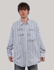 Front view of model wearing a blue Love Will striped shirt with black lettering, pointed collar and long sleeves.