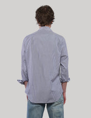 Back view of a blue and white pinstripe cotton shirt showing the relaxed fit, long sleeves and curved hem.