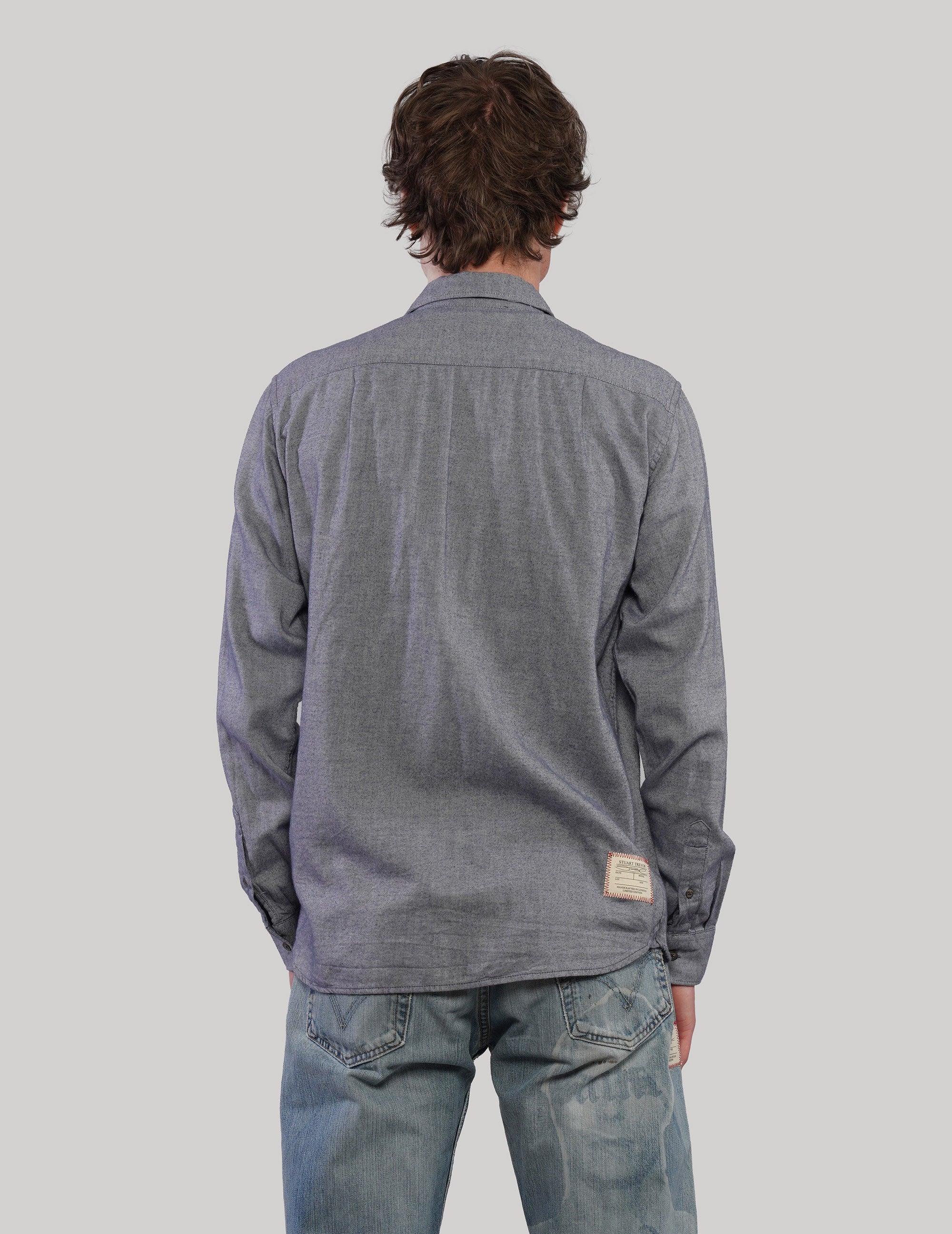 Full back view of a grey vintage cotton shirt showing its textured fabric, button cuffs and small label near the lower hem.