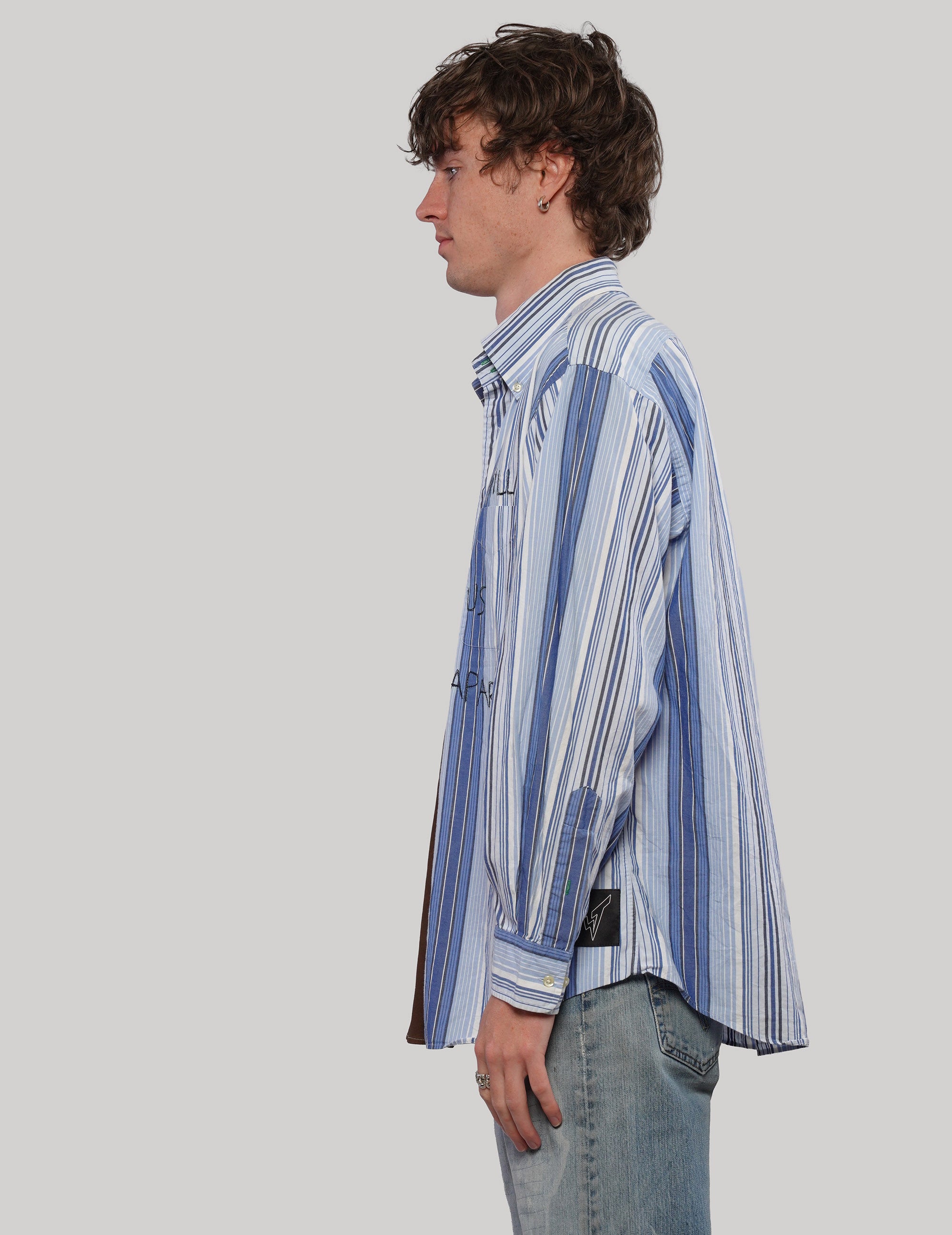 Side view of the 'Love Will' split shirt showing its blue and white striped panel, pointed collar and long sleeves.