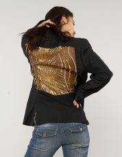Model wearing black vintage tuxedo jacket with sheer gold sequin party back, photographed from behind.
