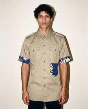 Reworked olive military shirt showing tropical print cuffs and hip patch pocket