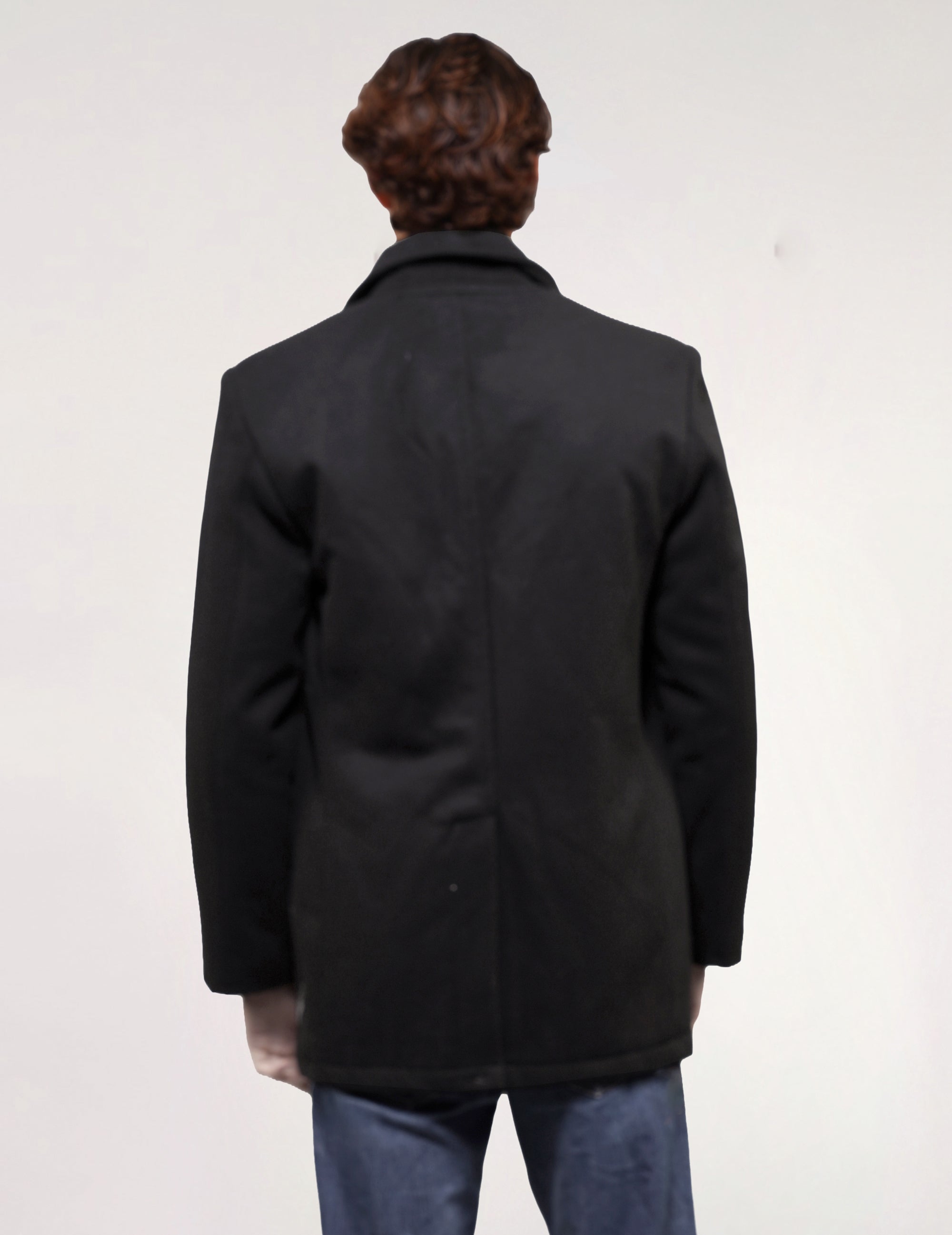 Rear view of black vintage naval peacoat showing its straight silhouette and mid-length cut.