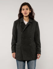 Model wearing a vintage charcoal AllSaints double-breasted peacoat with structured collar and button detailing.