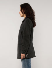 Side profile of model wearing a vintage charcoal AllSaints peacoat with long sleeves and structured fit.